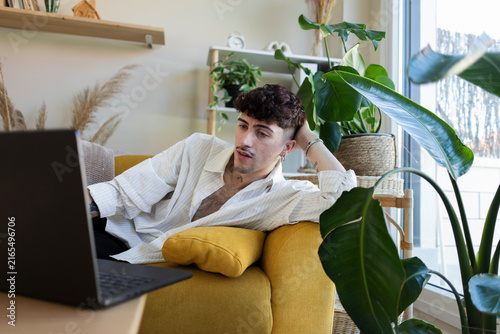 Young man relaxing watching laptop at home