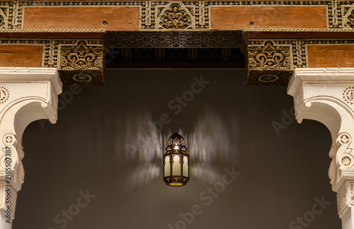 Illuminated Traditional Moroccan Lantern and Intricate Shadow Play in a Historic Marrakech Archway