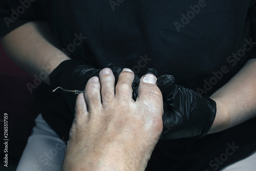 Foto Close up of a professional nail technician using a metal instrument during a pedicure procedure