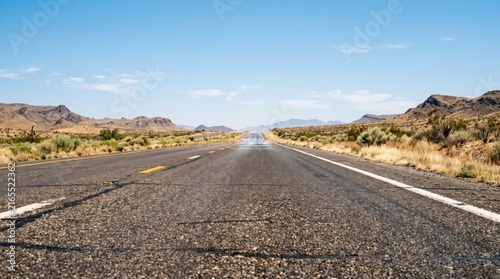Desert Highway Journey: An empty asphalt highway stretches towards the horizon under a clear blue sky, flanked by arid desert landscape and distant mountains, suggesting an open road adventure.