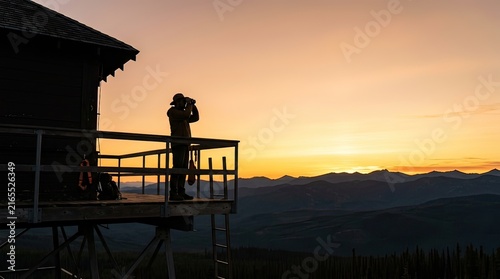 silhouette of a photographer at sunset on a mountain lookout