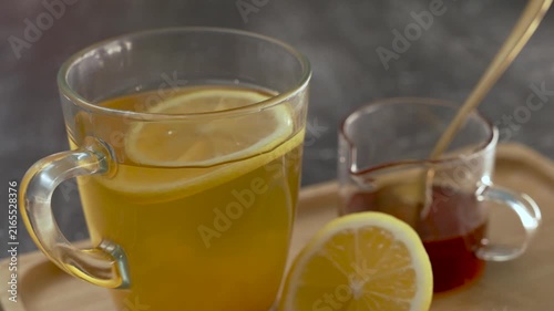 Honey Lemonade in a glass on a table on a wooden tray.