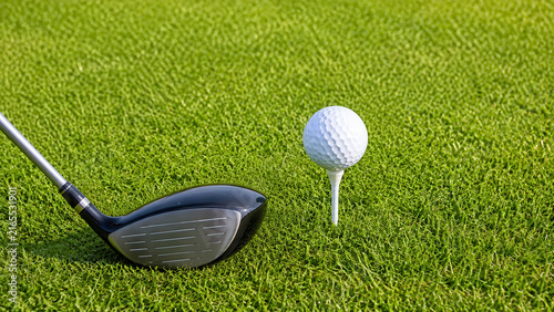 Pallina da golf sul tee accanto alla testa del driver sul prato verde. Generative AI 