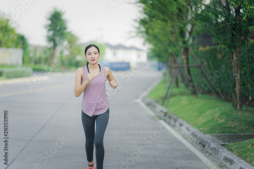 Obraz na plátně Young Asian woman in sportswear jogging and exercising outdoors in the park