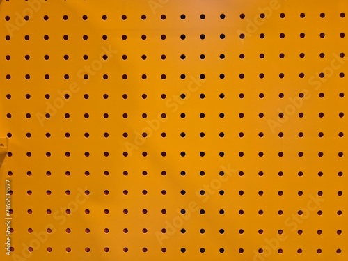 Foto Bright orange pegboard with evenly spaced holes