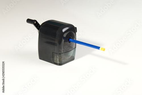 Foto A classic black desktop pencil sharpener with a blue pencil inserted, ready for sharpening