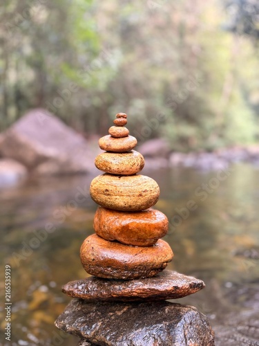 Balanced Stack of Smooth River Stones in Forest Stream Close Up