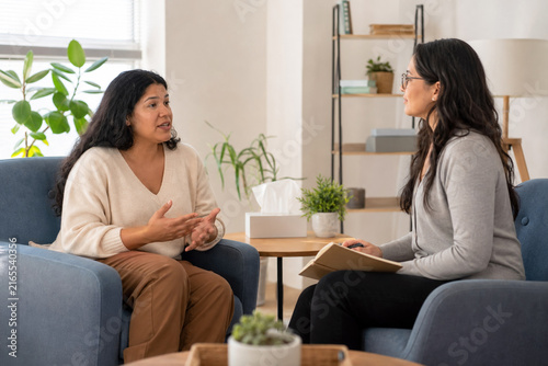 Adult Client Sharing Feelings with an Empathetic Female Therapist during a Supportive Private Counseling Session in a Welcoming Office