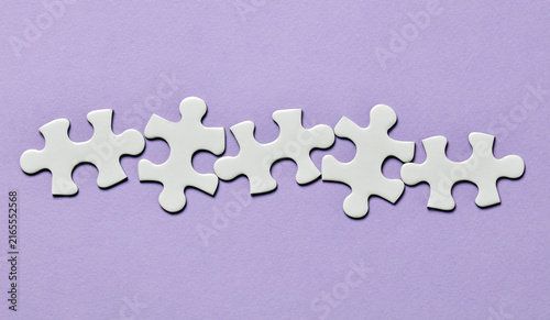 Фотография Row of separate puzzle pieces on purple background