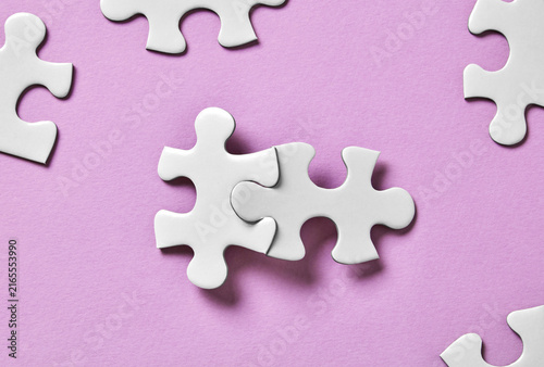 Two connected puzzle pieces with scattered pieces