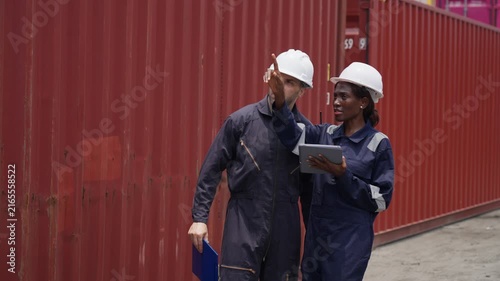 Engineers discussing project details at shipping yard for logistics efficiency
