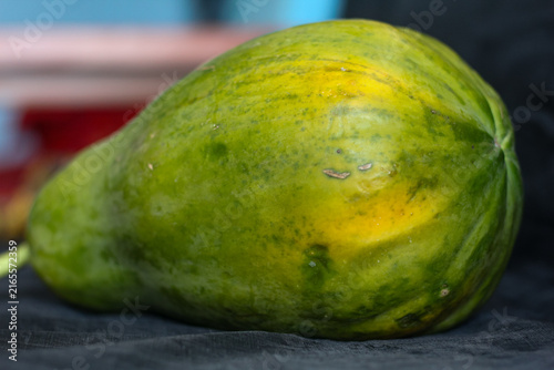 Green Whole Papaya on Dark Cloth Surface