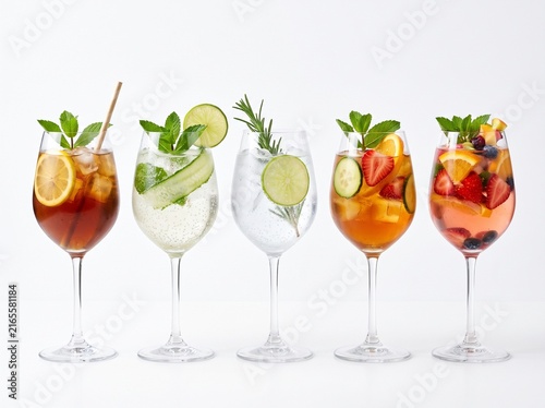cocktail set with iced tea elderflower mint spritz gin tonic pimms cup and pink sangria in stemmed wine glasses isolated on a white background