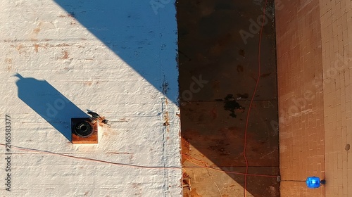 Overhead view of industrial elements and textures under bright sunlight.