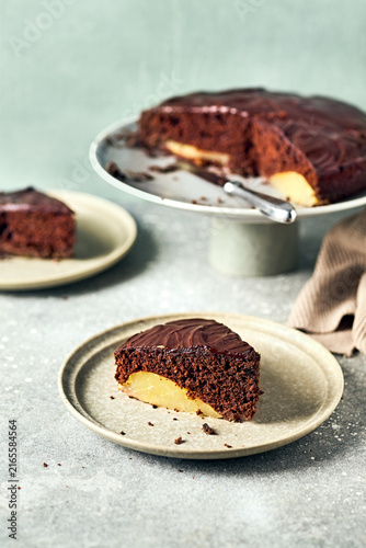 Sliced chocolate pear cake with ganache glaze on a ceramic plate