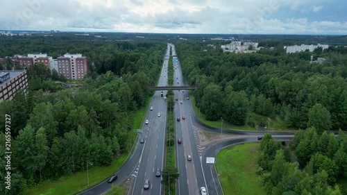 Cinematic aerial drone footage between Kannelmäki and Pohjois-Haaga, Helsinki, Finland, flying smoothly over the green urban landscape on a cloudy summer day.