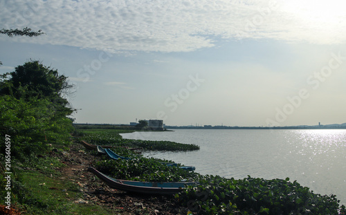 Canvastavla serene lakeside scene near Chengalpattu features wooden boats resting among wate