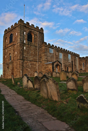 Historic St Mary's Church and Churchyard, Whitby, North Yorkshire; ancient graveyard with weathered tombstones associated with Bram Stoker's Dracula, heritage religious building under blue cloudy sky