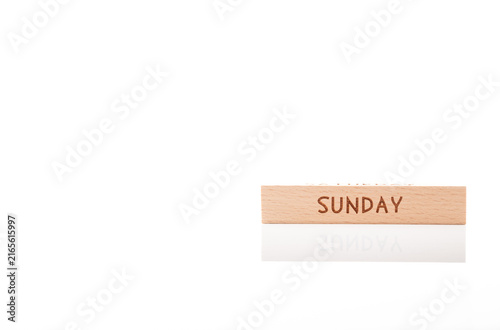 Konstfotografi Wooden cube with engraved word SUNDAY on white background with soft reflection