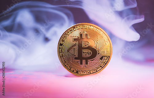 Fotografie Golden Bitcoin coin with dramatic smoke background illustrating volatile cryptocurrency market concept