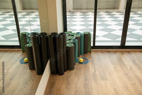 Rolled fitness yoga mats standing in corner of gym fitness studio