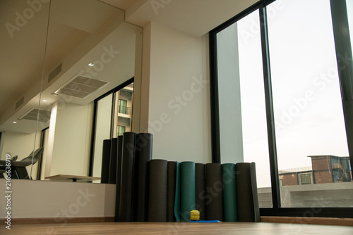 Rolled fitness yoga mats standing in corner of gym fitness studio