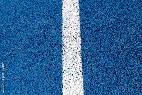 Blue running track lanes with white painted lines