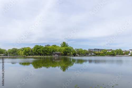 Quadro su tela Tranquil Lake Park with Pavilion and Tree Reflections