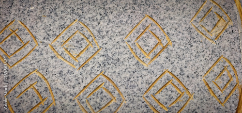 Fotografía Carved geometric diamond pattern on gray granite stone surface