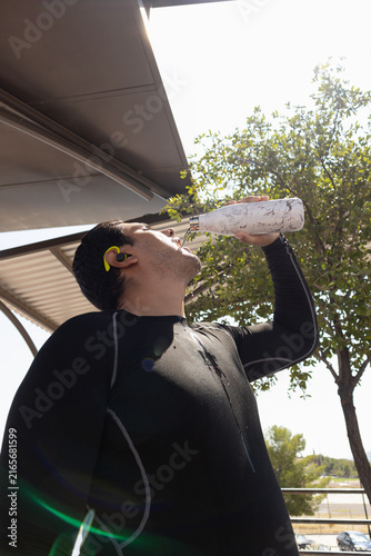 Картината върху платно Athletic man rehydrating during outdoor fitness training, drinking water from a