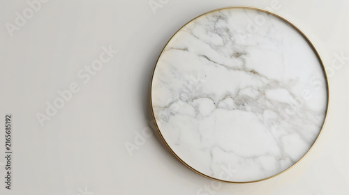 Flat lay top down view of off-center circular white marble tray with gold border and generous copy space