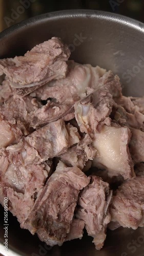 Cooking Thai pork rib soup with peanuts (Tom Soup Kra Dook Moo Thua Li Song). Blanching ribs, simmering with white pepper, coriander roots, peanuts, preserved radish, and seasonings.