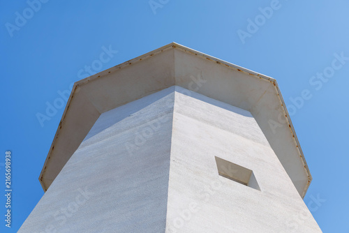 A lighthouse with white exterior walls bathed in sunlight