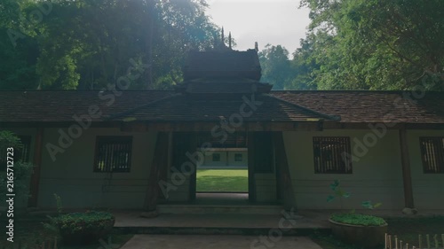 Entrance to Wat Phra Lat Buddhist temple by tropical forest in Chiang Mai Thailand, Traditional monastery architecture with peaceful garden courtyard and lush greenery at sunset 4k