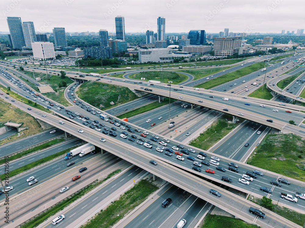 Obraz premium Busy highway interchange with city skyline in North York Ontario
