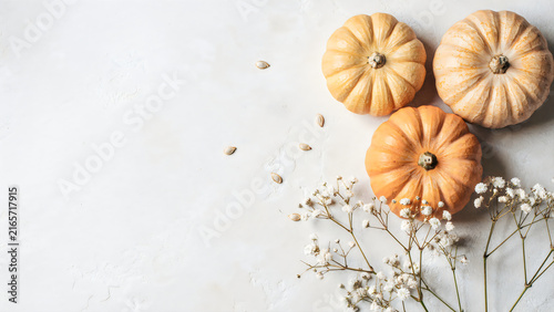 Three carved Halloween pumpkins with lit candles on rustic wooden table for spooky decoration