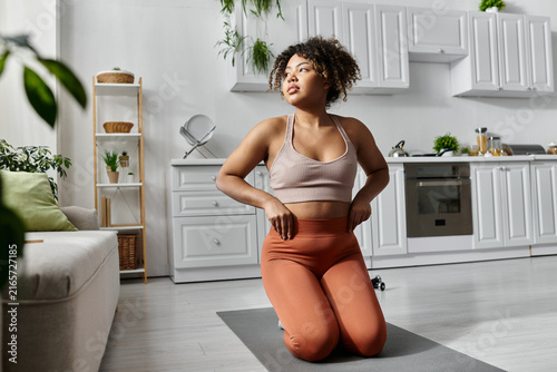 Konstfotografi Beautiful young African American woman practicing yoga in her cozy home