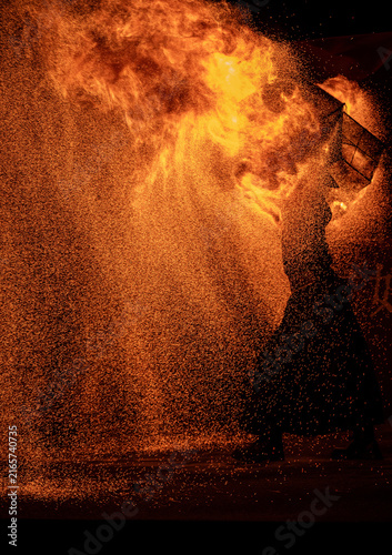 Fotografie Fire Performer in a Storm of Flames and Sparks