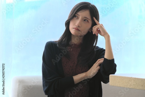 Quadro su tela 窓際で頭に指をあてて深く悩み考える若い女性（悩み・思考・ストレスイメージ）