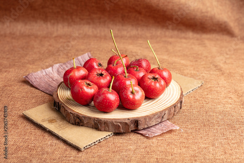 Fotografía Red hawthorn fruits on wooden slice in rustic autumn setting