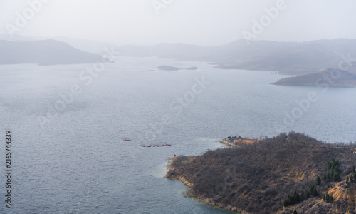 Принти на полотні Misty Reservoir with Distant Mountains and Tranquil Water