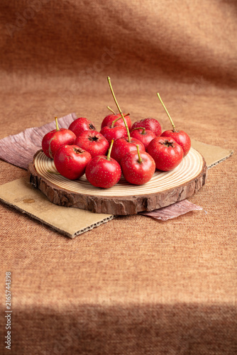 Cuadro en lienzo Red hawthorn fruits on wooden slice with rustic brown background