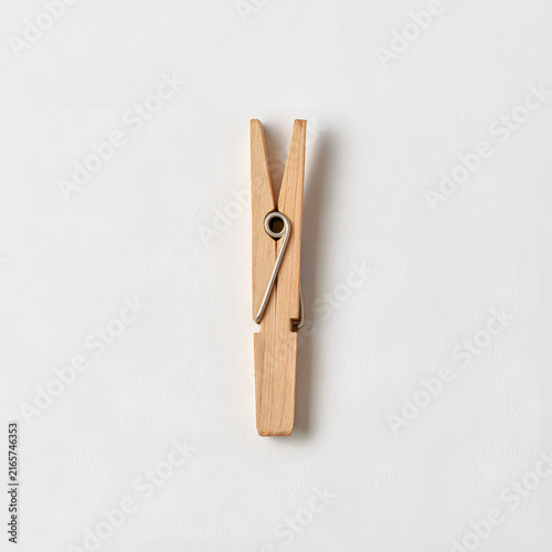 A simple wooden clothespin, showcasing its natural texture and design against a clean white background.