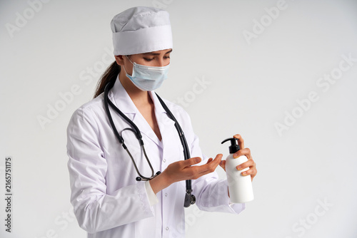 doctor applying antibacterial spray on hand on white background