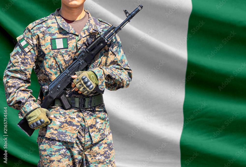 Fototapeta premium Nigeria flag with soldier holding assault rifle