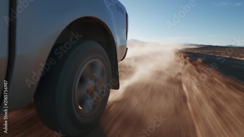 Offroad SUV / Pick Up Truck driving through Campo de Piedra Pomez in Catamarca Argentina. Rear Wheel detail POV, sunrise.