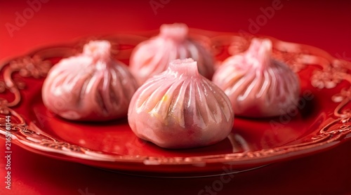 Gourmet Pink Steamed Dumplings on a Vibrant Red Plate