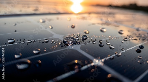 Water Droplets on Solar Panel Reflecting Golden Sunset Light