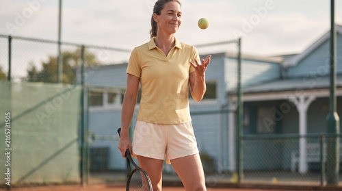 Smiling Female Tennis Player Tossing Ball on Outdoor Court