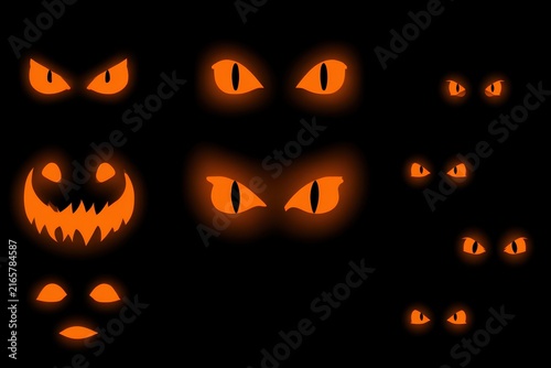 Glowing Halloween pumpkin eyes and spooky jack-o-lantern faces isolated on black background.